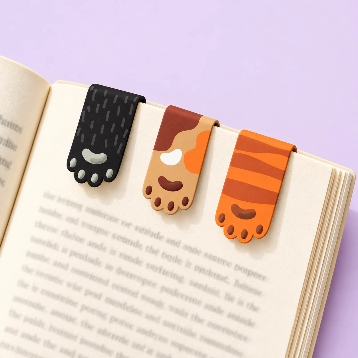 Cat-paw magnetic bookmarks clipped to a book